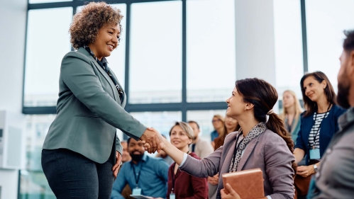 Teacher shakes student hand